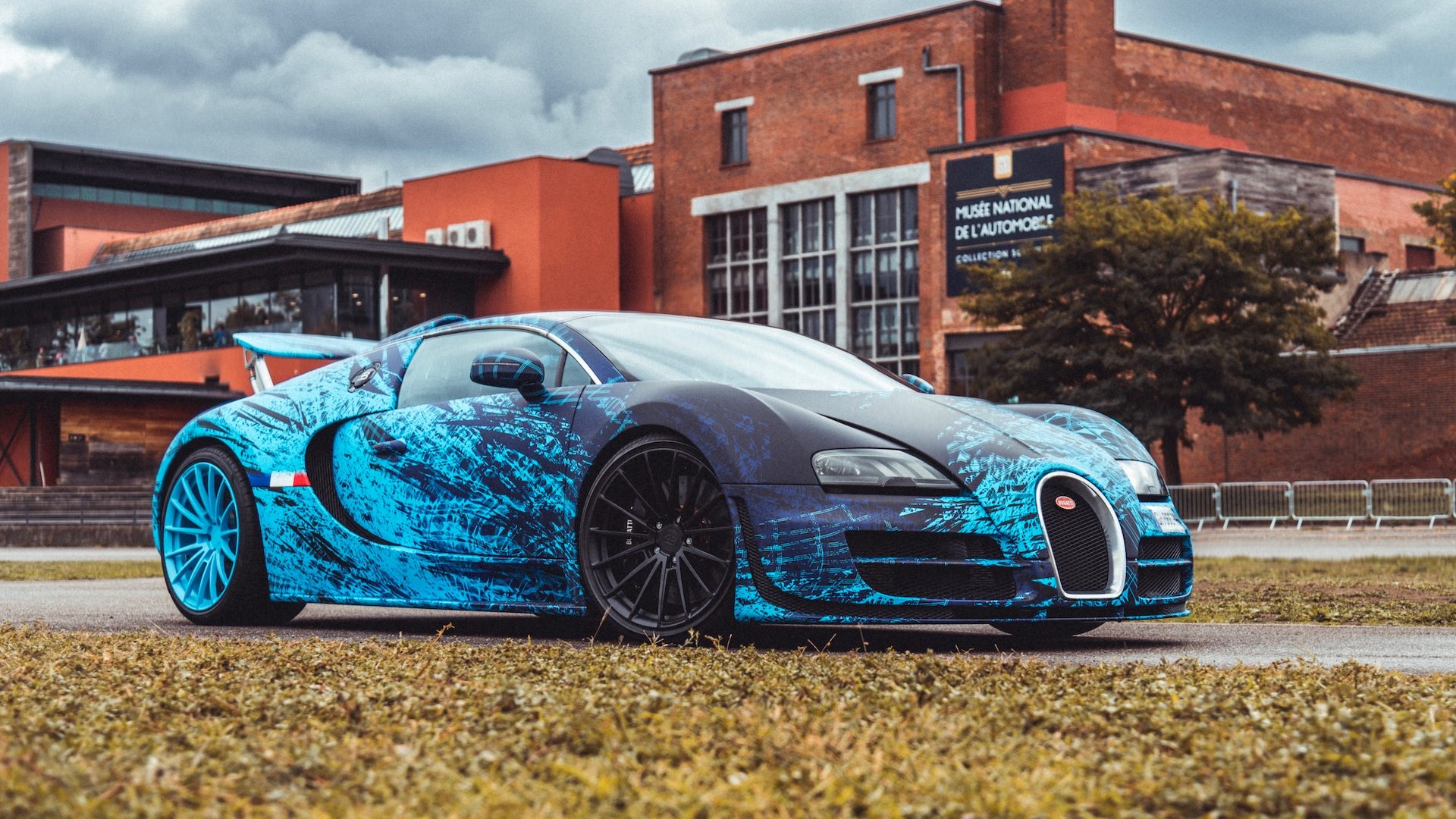 Bugatti Veyron Grand Sport Vitesse devant le musée Bugatti Veyron avec wrapping bleu personnalisé devant le Musée National de l'Automobile