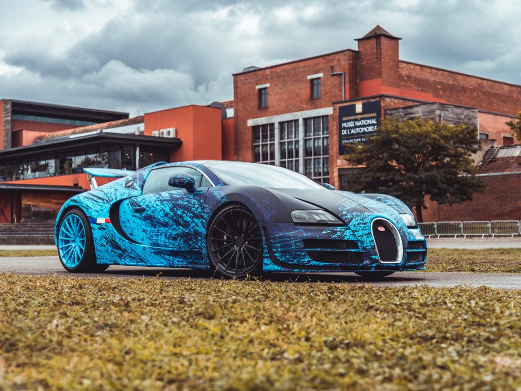 Bugatti Veyron Grand Sport Vitesse POGATTI covering bleu Nathan Haëtty devant le Musée National de l'Automobile.