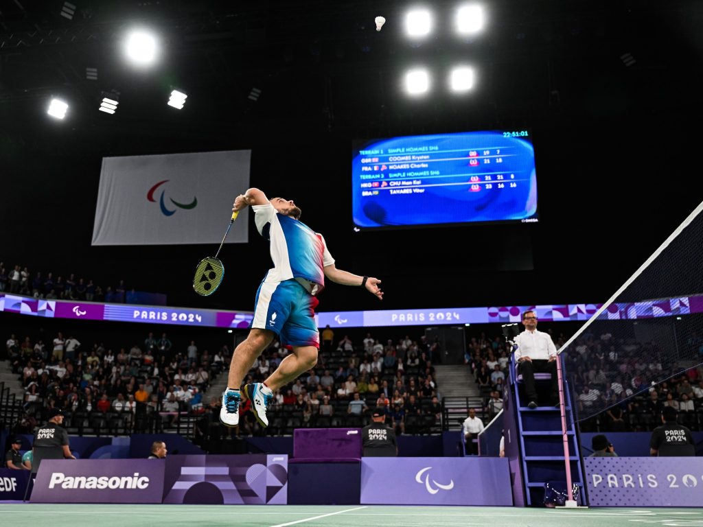 Charles Noakes, joueur de para-badminton français, en plein smash aérien aux Jeux Paralympiques Paris 2024.