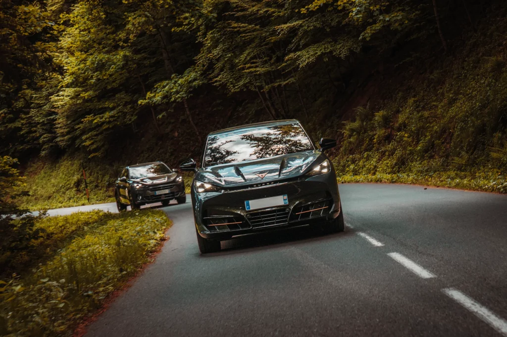 Cupra Tavascan et Formentor conduisant sur une route sinueuse en forêt alsacienne