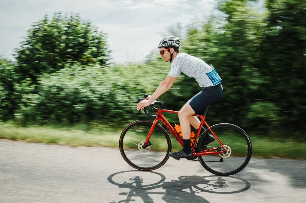 Cycliste sur un vélo Canyon rouge en plein effort lors des Boucles Škoda à Colmar.