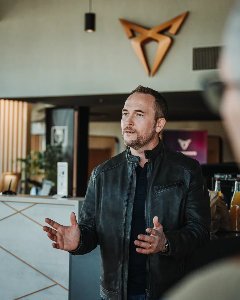 Manager Cupra Mulhouse en veste cuir faisant une présentation lors du roadshow événementiel.